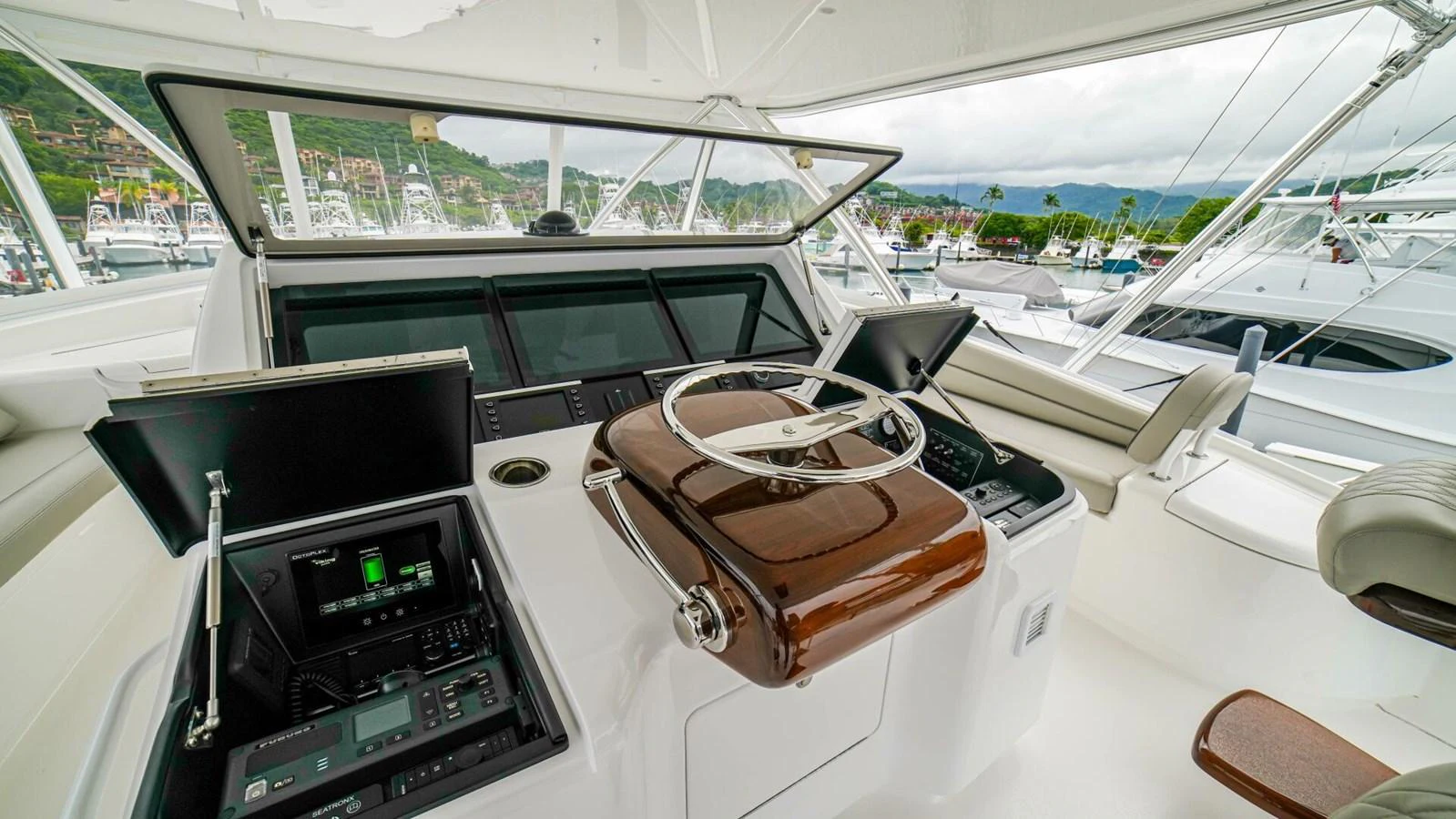 The helm station features advanced navigation equipment and a comfortable steering wheel setup. aboard FREE SPOOL Yacht for Sale