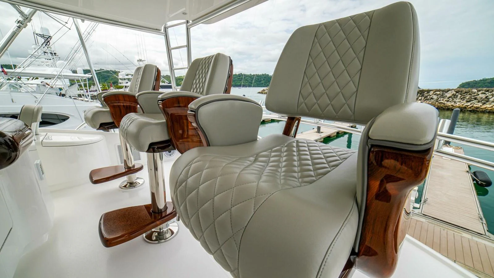 Luxurious helm chairs with elegant stitching and polished wood accents. aboard FREE SPOOL Yacht for Sale