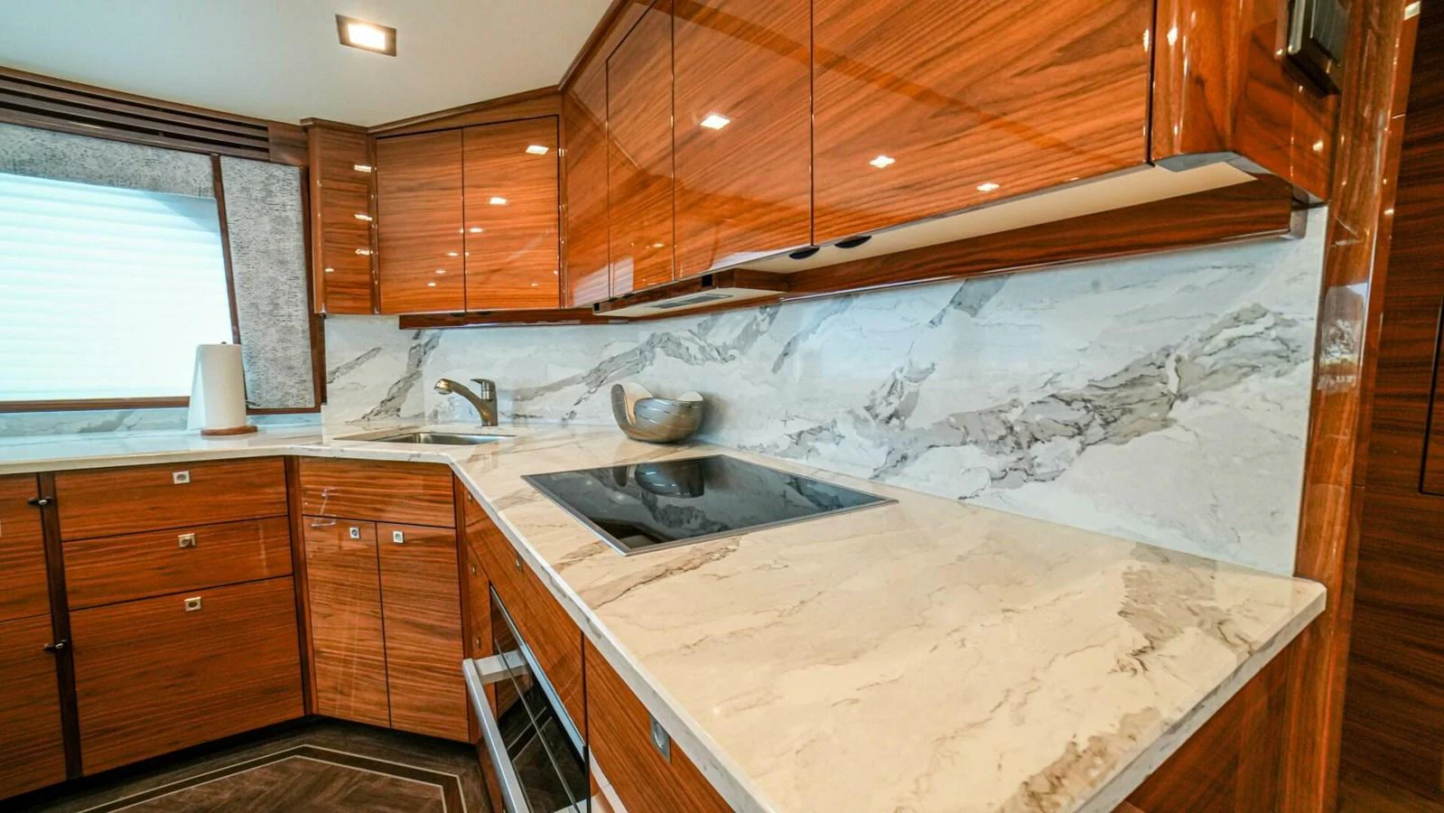 The yacht's galley features elegant wood cabinetry and modern appliances. aboard FREE SPOOL Yacht for Sale