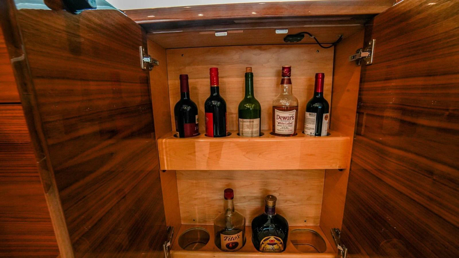 A well-stocked bar cabinet with various bottles of liquor. aboard FREE SPOOL Yacht for Sale