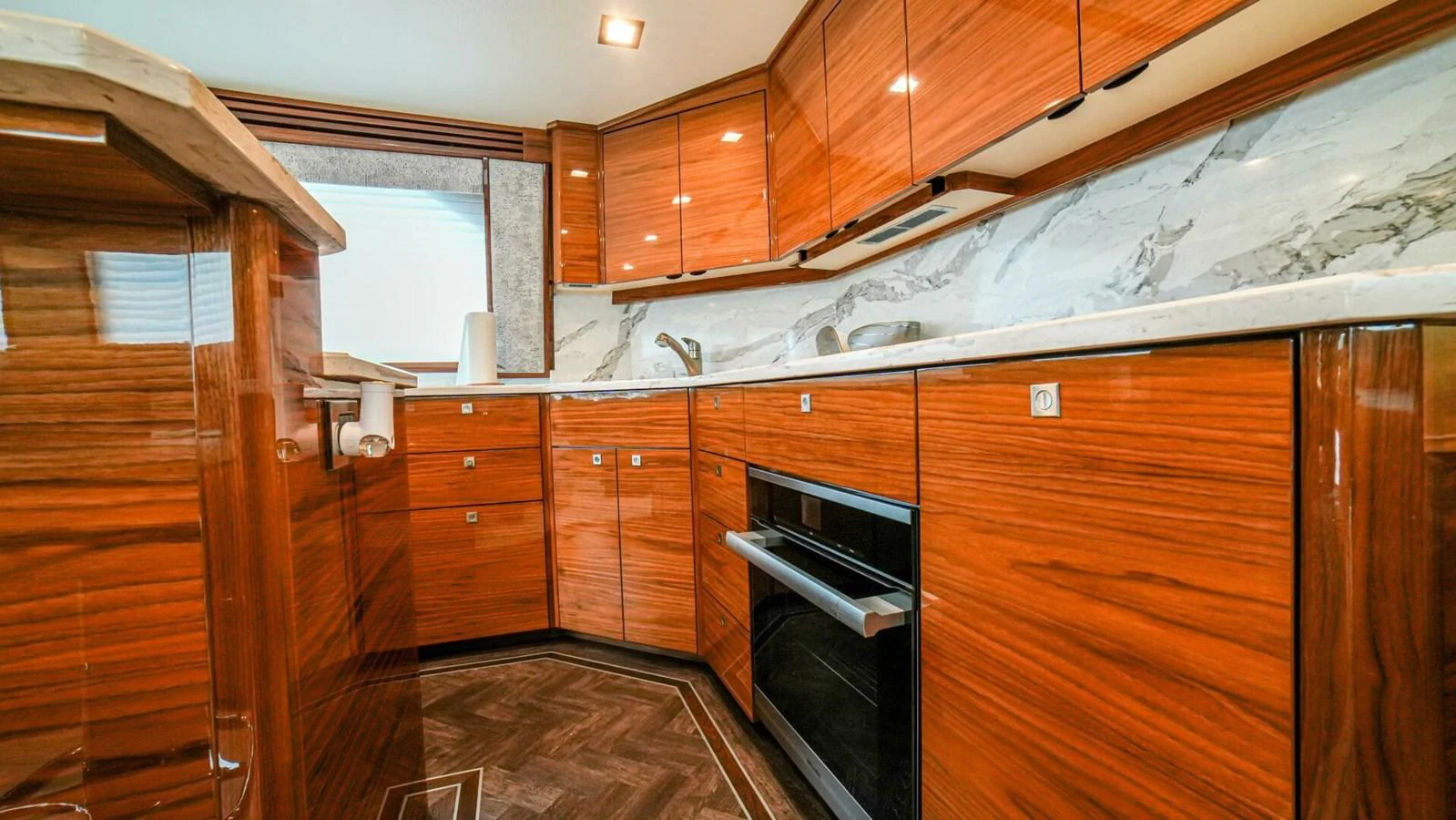 The yacht's galley features rich wood cabinetry and modern appliances. aboard FREE SPOOL Yacht for Sale
