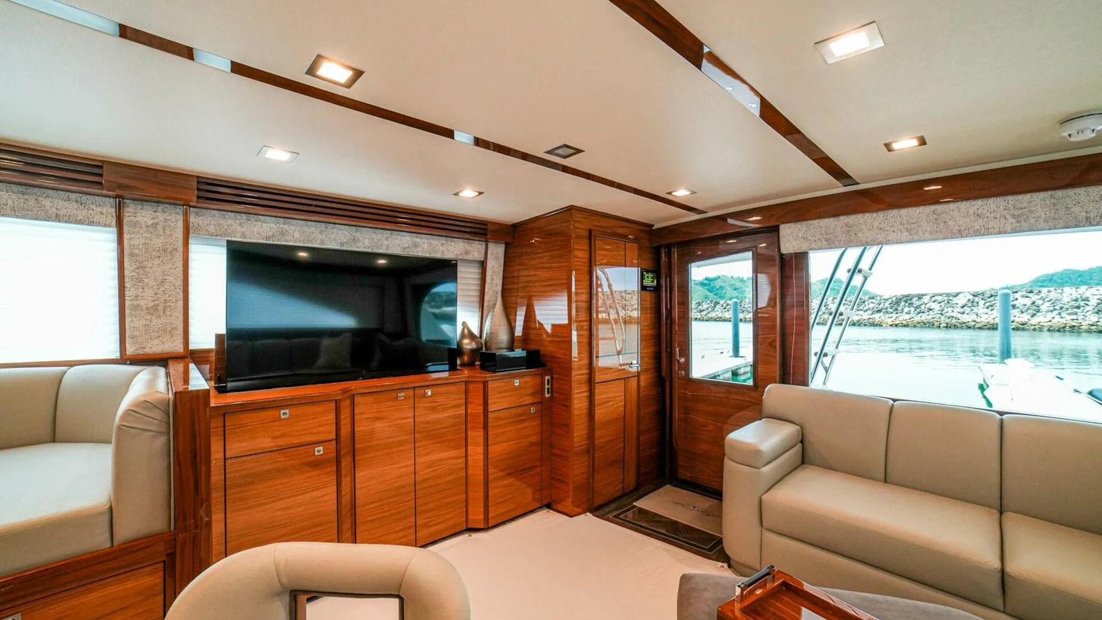 The yacht's salon features luxurious seating and a large television for entertainment. aboard FREE SPOOL Yacht for Sale