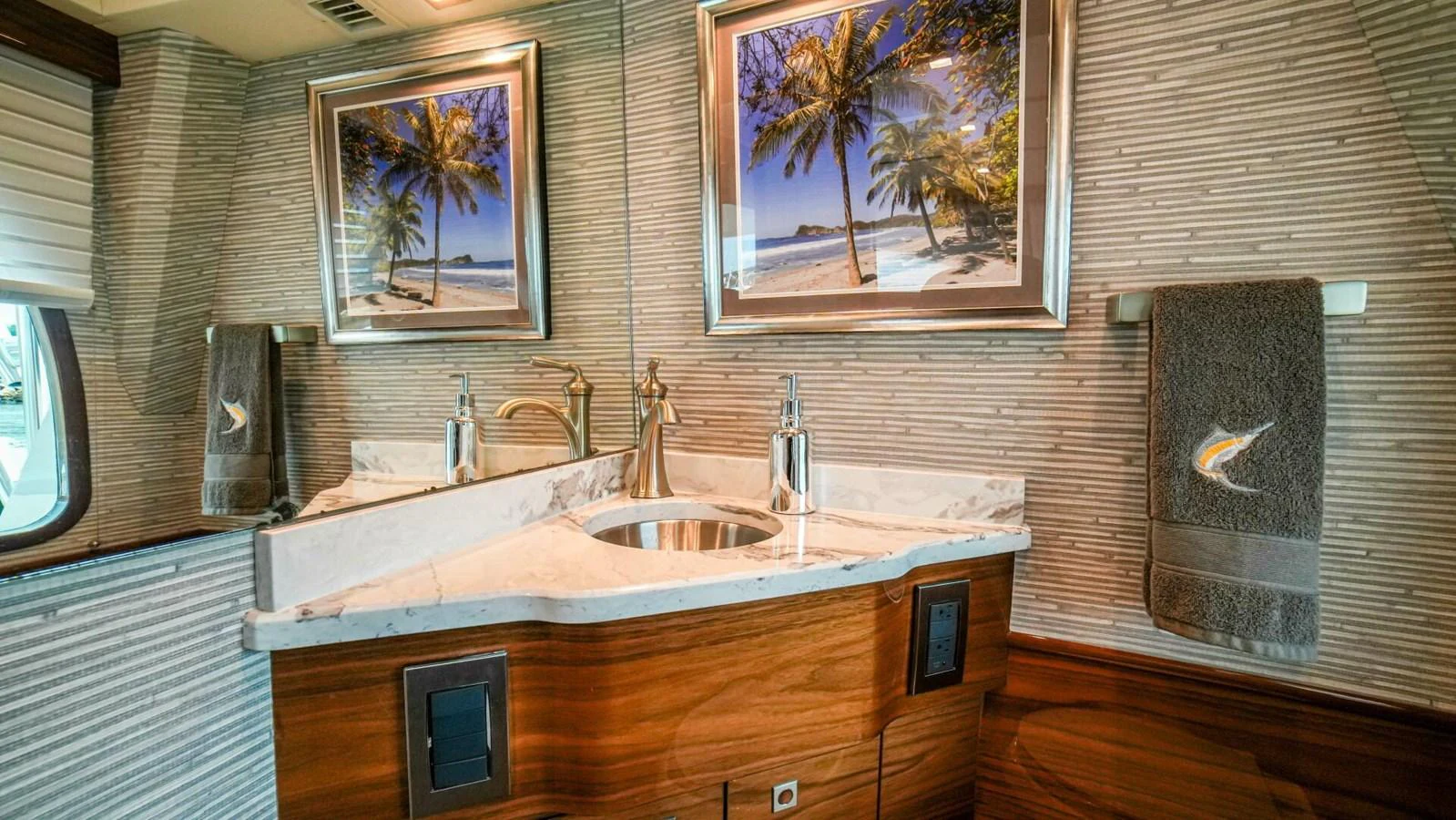 A luxurious yacht bathroom featuring elegant fixtures and tropical-themed artwork. aboard FREE SPOOL Yacht for Sale