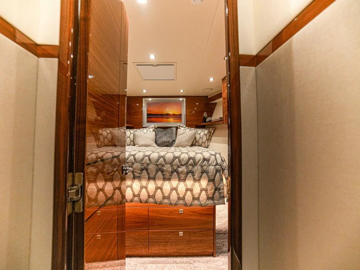 A luxurious stateroom featuring elegant wood finishes and a plush bed. aboard FREE SPOOL Yacht for Sale