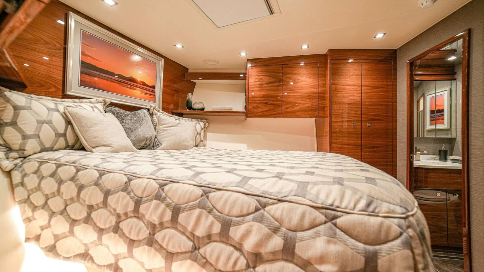 The stateroom features a comfortable bed with elegant wooden cabinetry and modern lighting. aboard FREE SPOOL Yacht for Sale