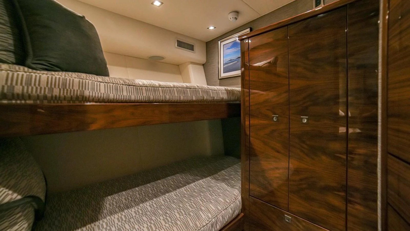 The guest cabin features cozy bunk beds and elegant wood cabinetry. aboard FREE SPOOL Yacht for Sale