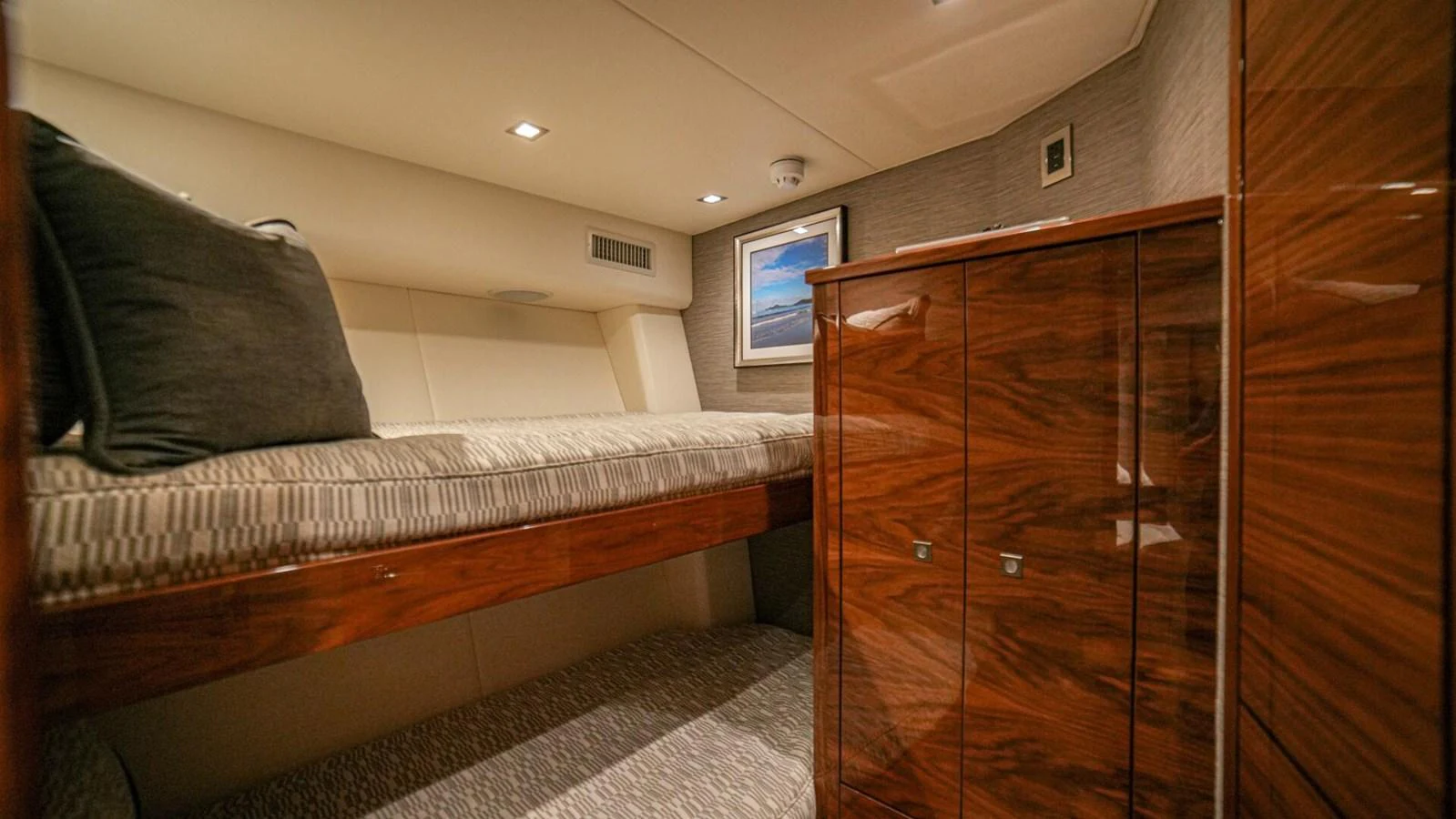 A cozy guest stateroom featuring elegant wood cabinetry and a comfortable bed. aboard FREE SPOOL Yacht for Sale