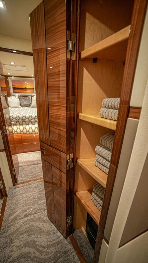 The image showcases a neatly organized linen closet within the yacht's interior. aboard FREE SPOOL Yacht for Sale