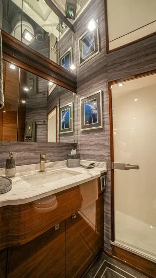 A luxurious yacht bathroom featuring elegant wood cabinetry and marble countertops. aboard FREE SPOOL Yacht for Sale