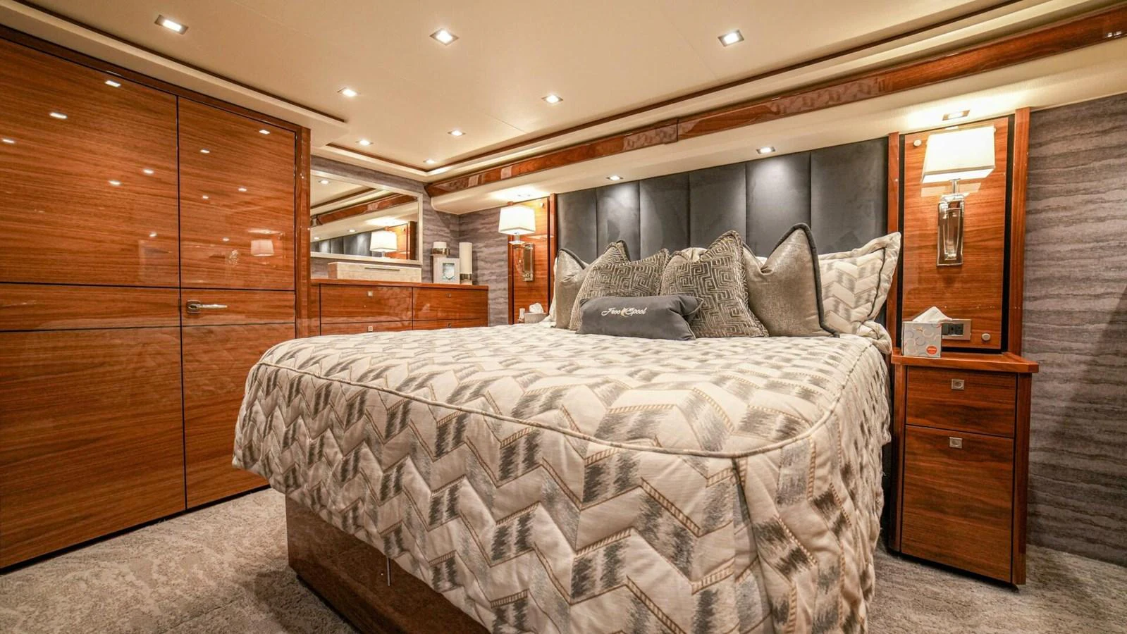 The master stateroom features a luxurious bed with elegant wood paneling and ambient lighting. aboard FREE SPOOL Yacht for Sale