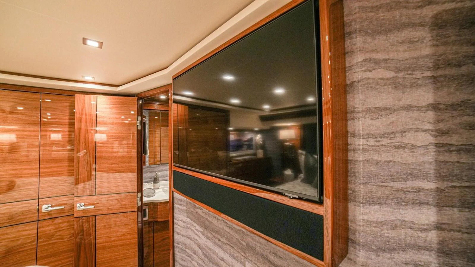 The yacht's interior features a large flat-screen television and elegant wood paneling. aboard FREE SPOOL Yacht for Sale