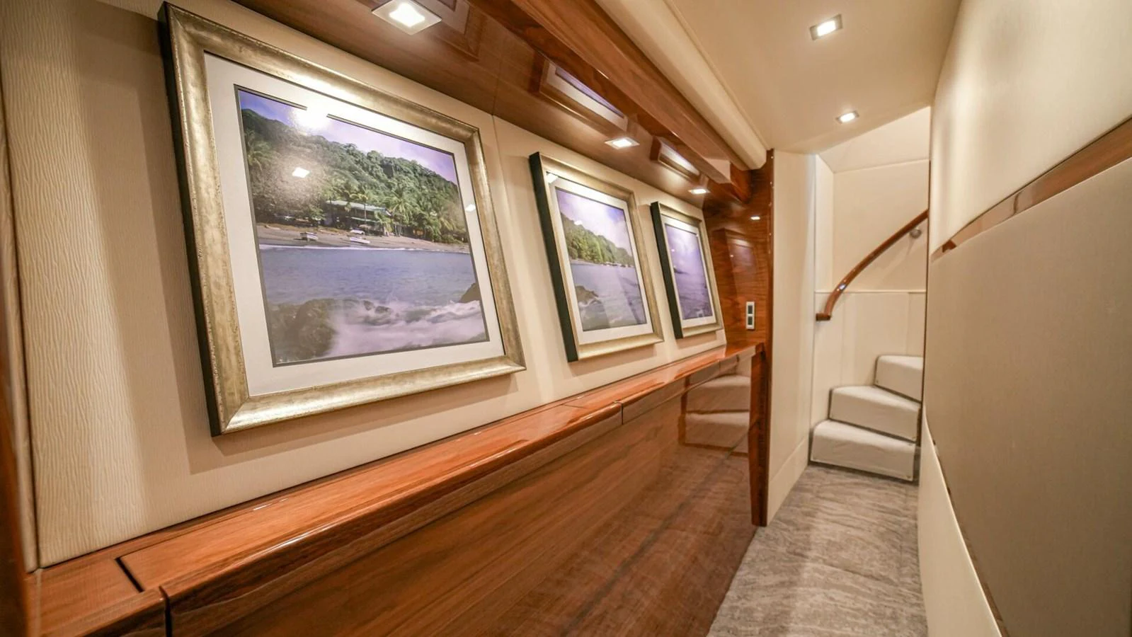 The yacht's hallway features elegant framed artwork and sophisticated lighting. aboard FREE SPOOL Yacht for Sale