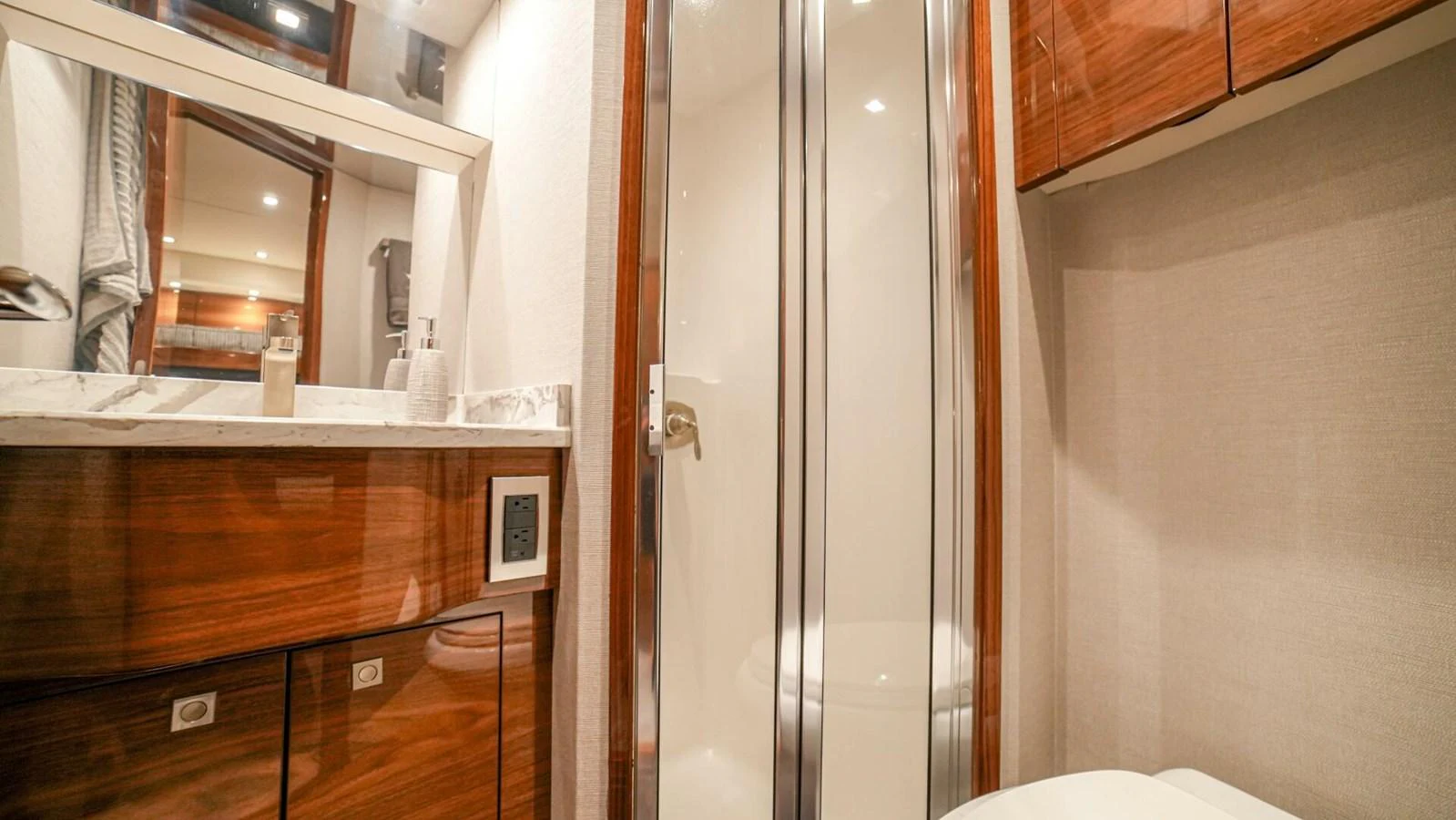 The yacht's bathroom features elegant wood cabinetry and a modern shower enclosure. aboard FREE SPOOL Yacht for Sale