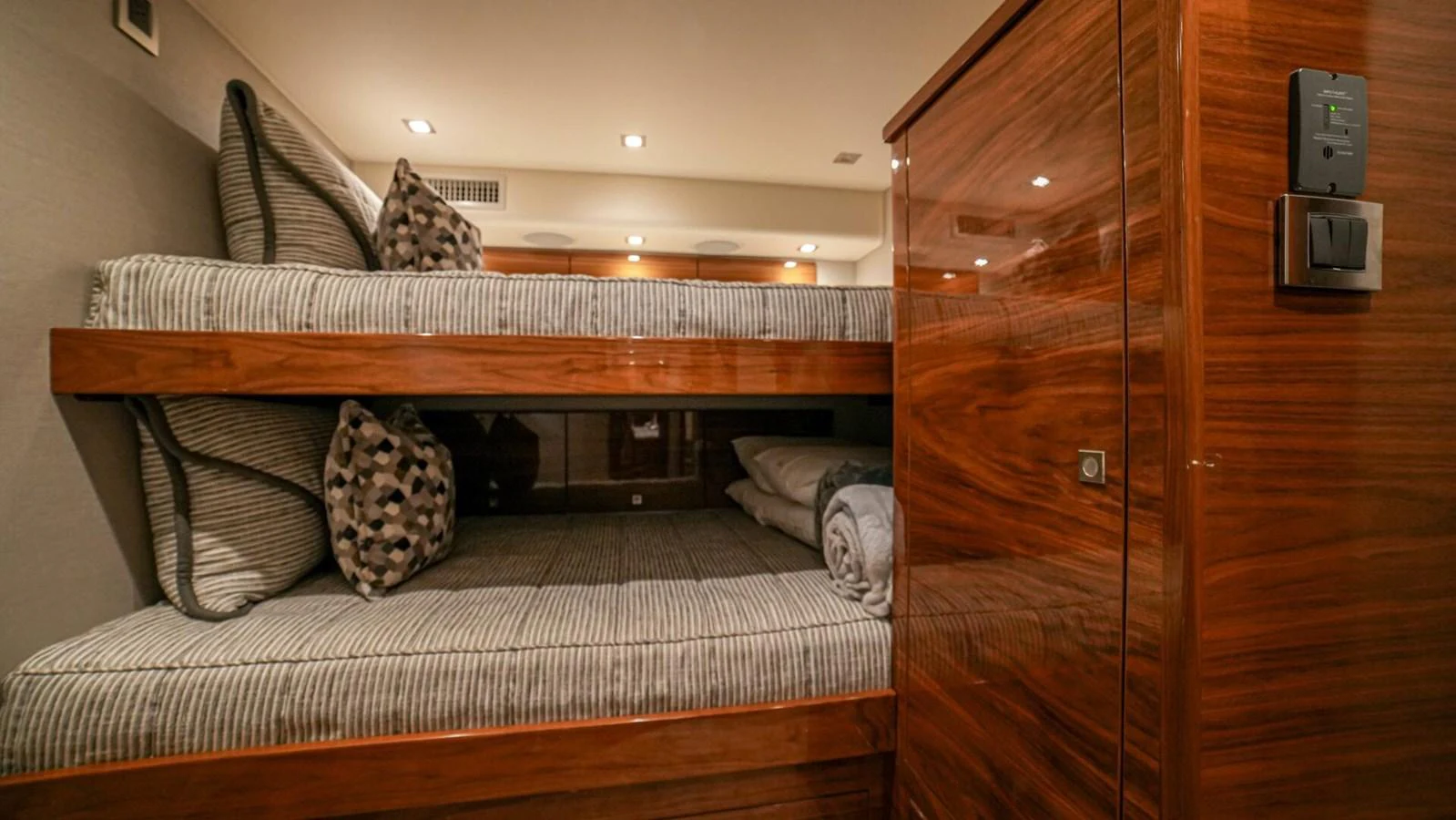 The image showcases a cozy bunk room with polished wood finishes and comfortable bedding. aboard FREE SPOOL Yacht for Sale