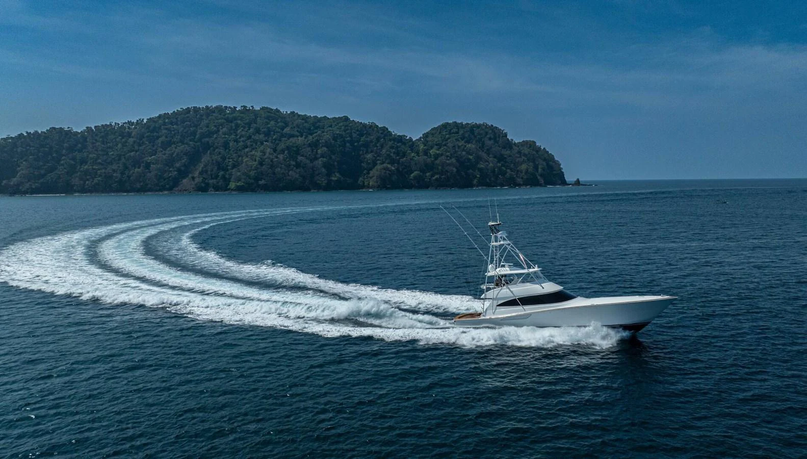A sleek yacht cruises swiftly through the open sea, leaving a graceful wake behind. aboard FREE SPOOL Yacht for Sale