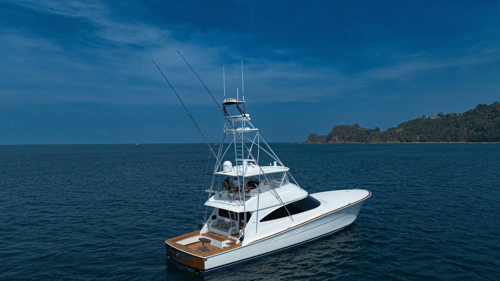A sleek yacht glides gracefully on calm waters under a clear blue sky. aboard FREE SPOOL Yacht for Sale