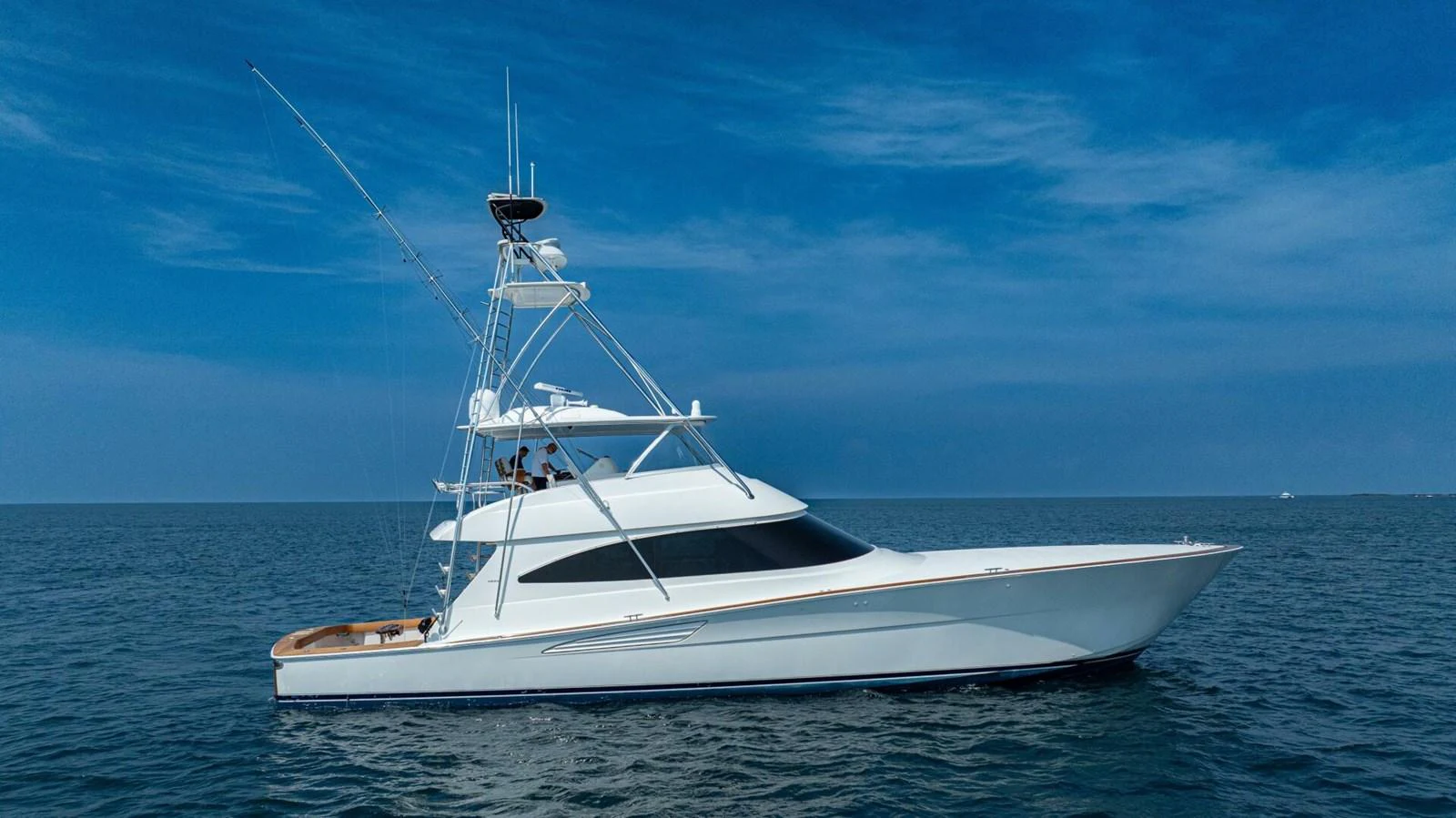 A sleek and elegant yacht cruising on calm blue waters under a clear sky. aboard FREE SPOOL Yacht for Sale