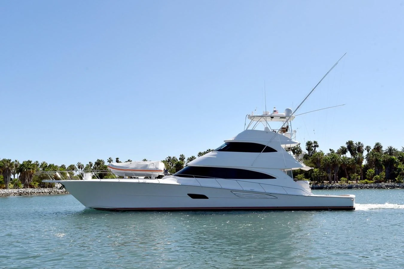 A sleek yacht cruising on calm waters under a clear blue sky. aboard PRIMETIME Yacht for Sale