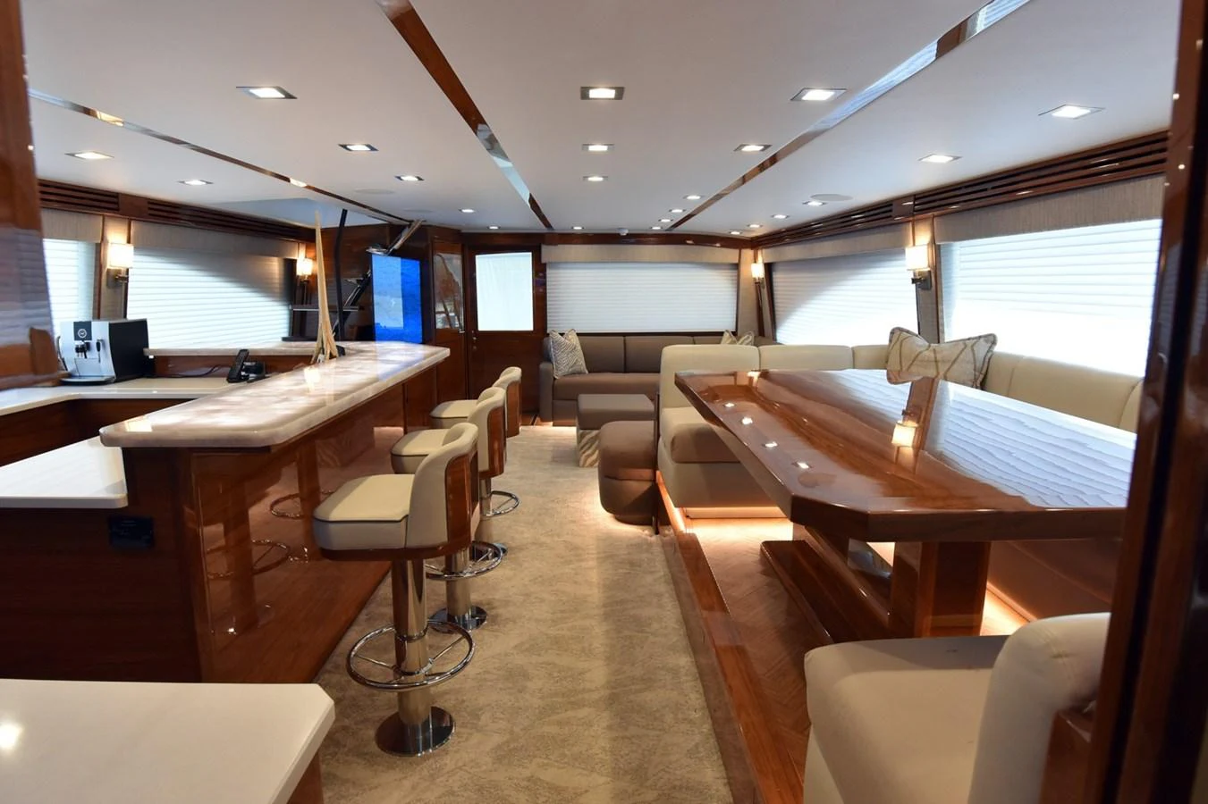 The yacht's salon features a spacious and luxurious seating area with a bar and dining table. aboard PRIMETIME Yacht for Sale