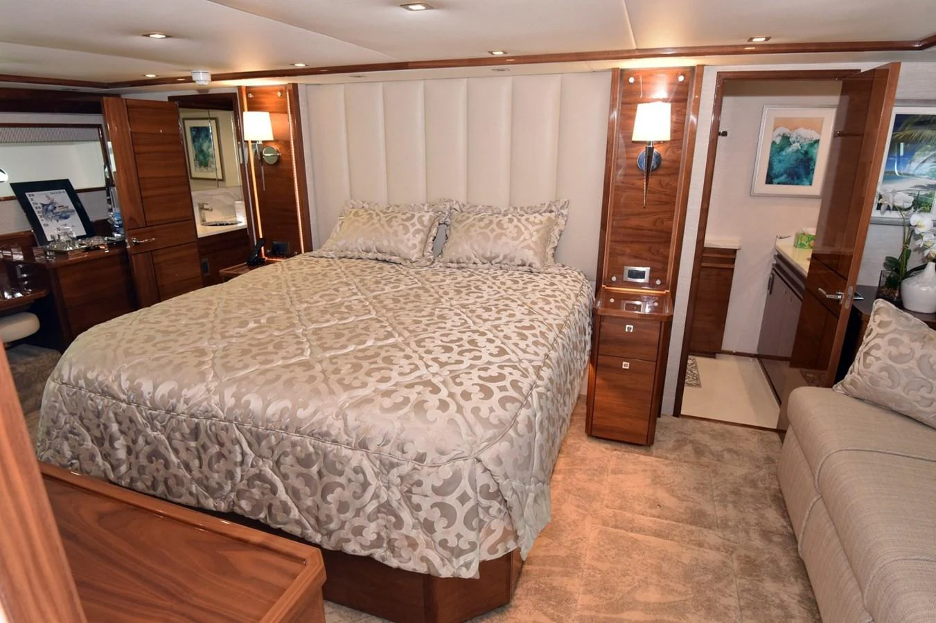 The master stateroom features a luxurious bed with elegant bedding and warm wood accents. aboard PRIMETIME Yacht for Sale