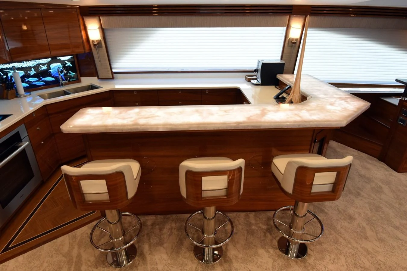 The yacht's galley features a sleek bar area with comfortable stools and modern appliances. aboard PRIMETIME Yacht for Sale