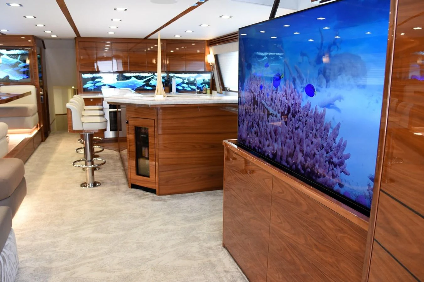 The yacht's interior features a modern entertainment area with a large flat-screen TV and elegant wood finishes. aboard PRIMETIME Yacht for Sale
