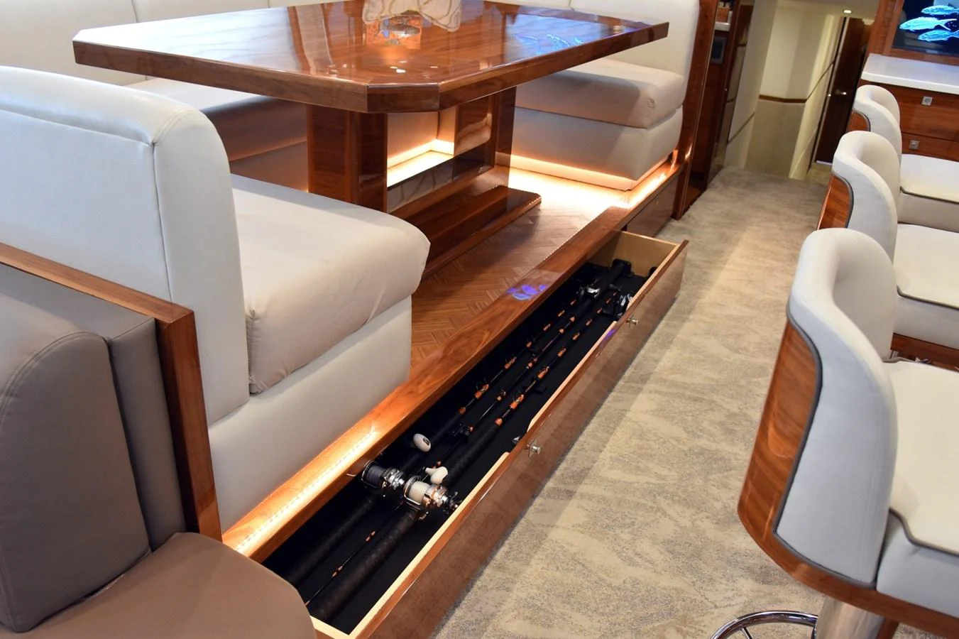 The image showcases a clever storage solution for fishing rods beneath a seating area. aboard PRIMETIME Yacht for Sale