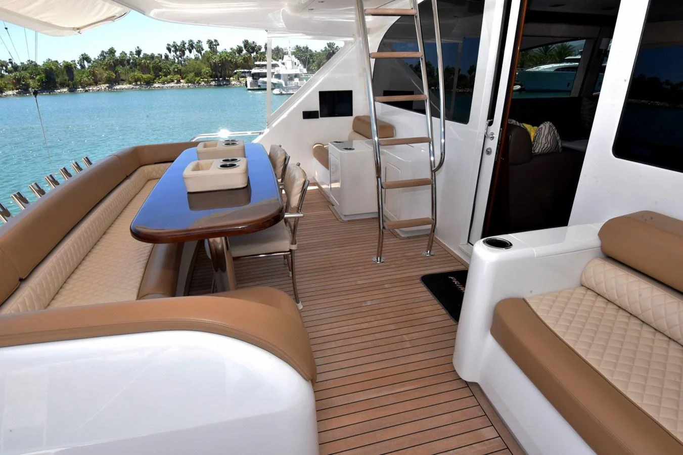 The aft deck features comfortable seating and a dining area with a view of the water. aboard PRIMETIME Yacht for Sale