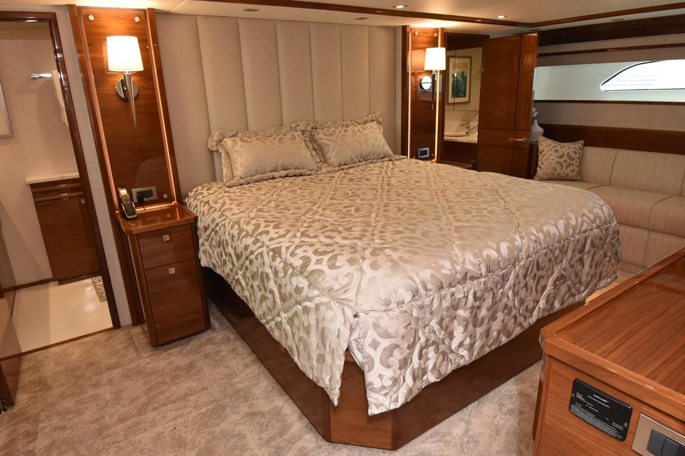The master stateroom features a luxurious bed with elegant bedding and warm wood accents. aboard PRIMETIME Yacht for Sale