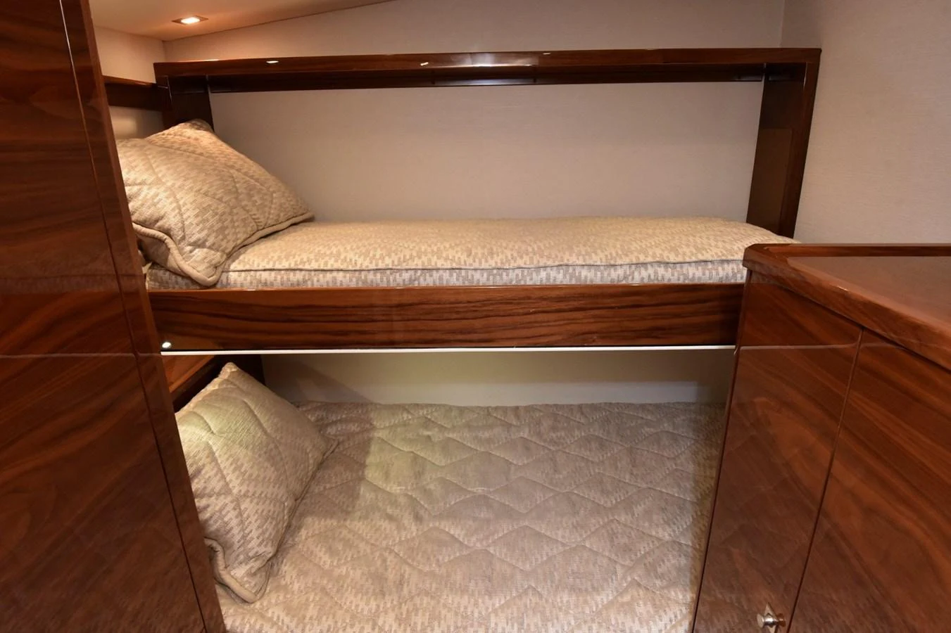 The cozy bunk cabin features warm wood finishes and comfortable bedding. aboard PRIMETIME Yacht for Sale