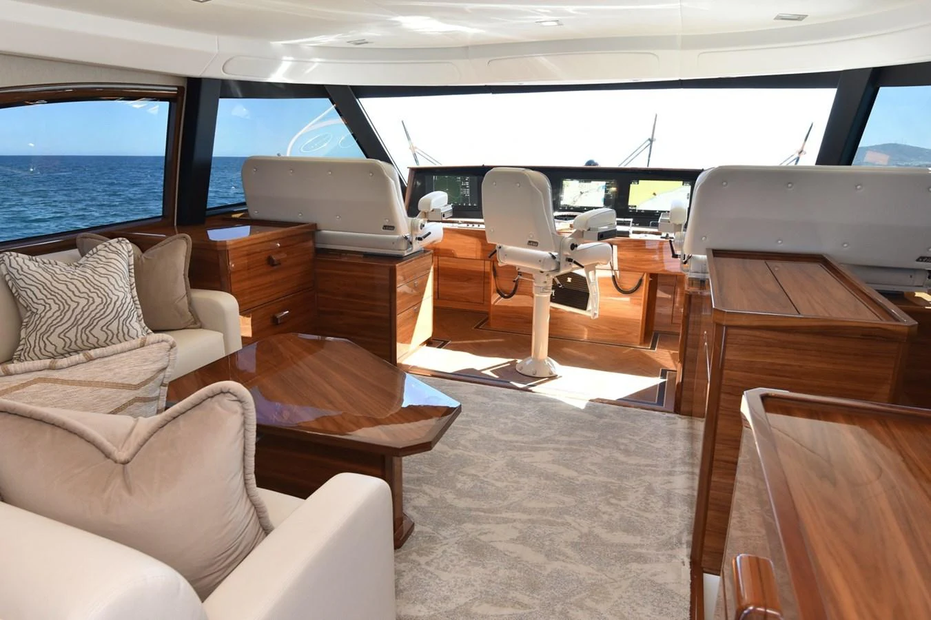 The helm area features comfortable seating and elegant wood finishes, offering a luxurious and functional space for navigation. aboard PRIMETIME Yacht for Sale