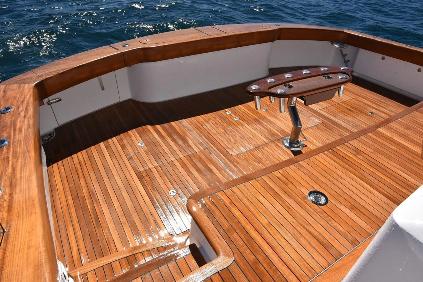 The yacht's aft deck features a polished wooden floor with a central table and ample space for relaxation. aboard PRIMETIME Yacht for Sale