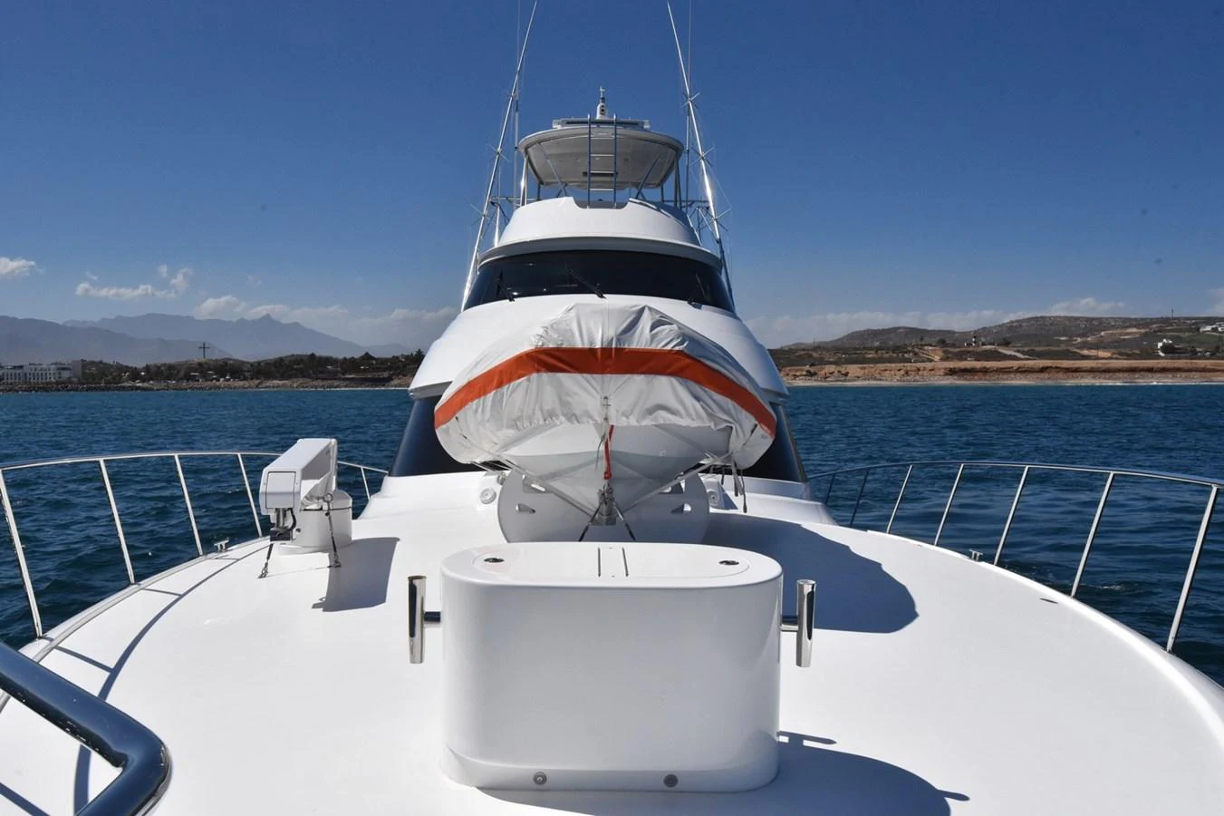 A sleek yacht is anchored in calm waters with a clear view of its bow and upper decks. aboard PRIMETIME Yacht for Sale