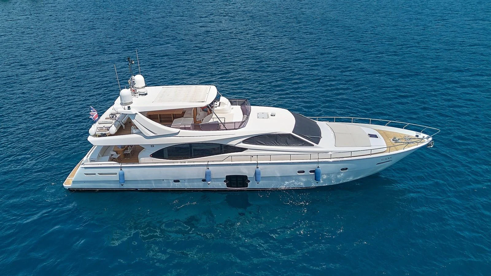 A sleek yacht glides gracefully on the clear blue waters. aboard GANS Yacht for Sale