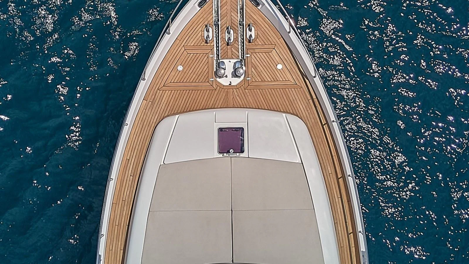 A detailed aerial view of the yacht's bow showcasing the teak decking and sun pad. aboard GANS Yacht for Sale