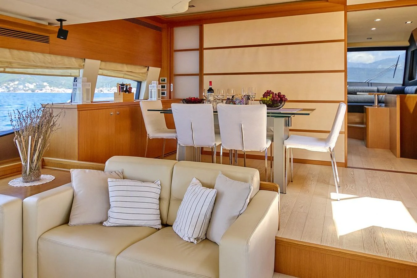 The yacht's interior features a stylish dining area adjacent to a comfortable seating space. aboard GANS Yacht for Sale
