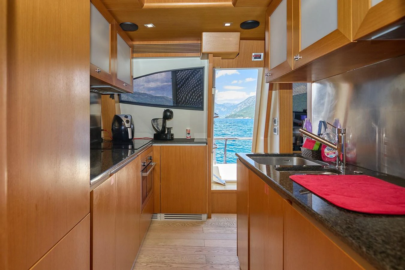 The yacht's galley features modern appliances and a scenic view through the doorway. aboard GANS Yacht for Sale