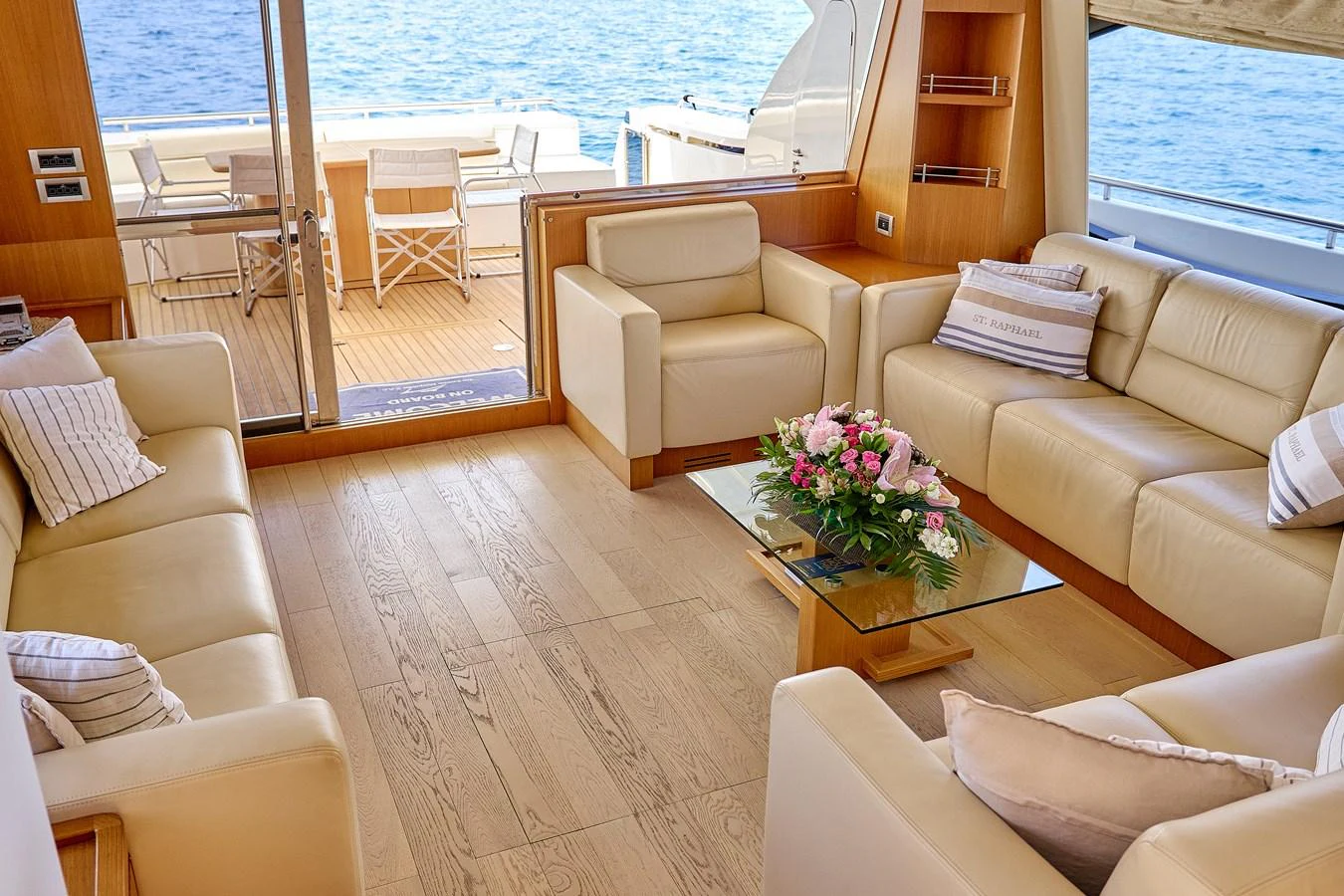 The salon features comfortable seating with a view of the aft deck and ocean beyond. aboard GANS Yacht for Sale