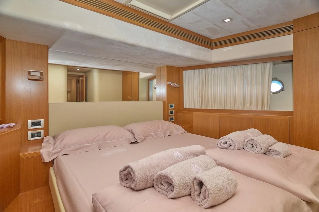 A cozy stateroom featuring a double bed with neatly arranged towels. aboard GANS Yacht for Sale