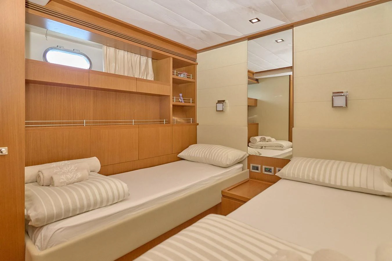 The guest cabin features twin beds with elegant wood paneling and ample storage space. aboard GANS Yacht for Sale