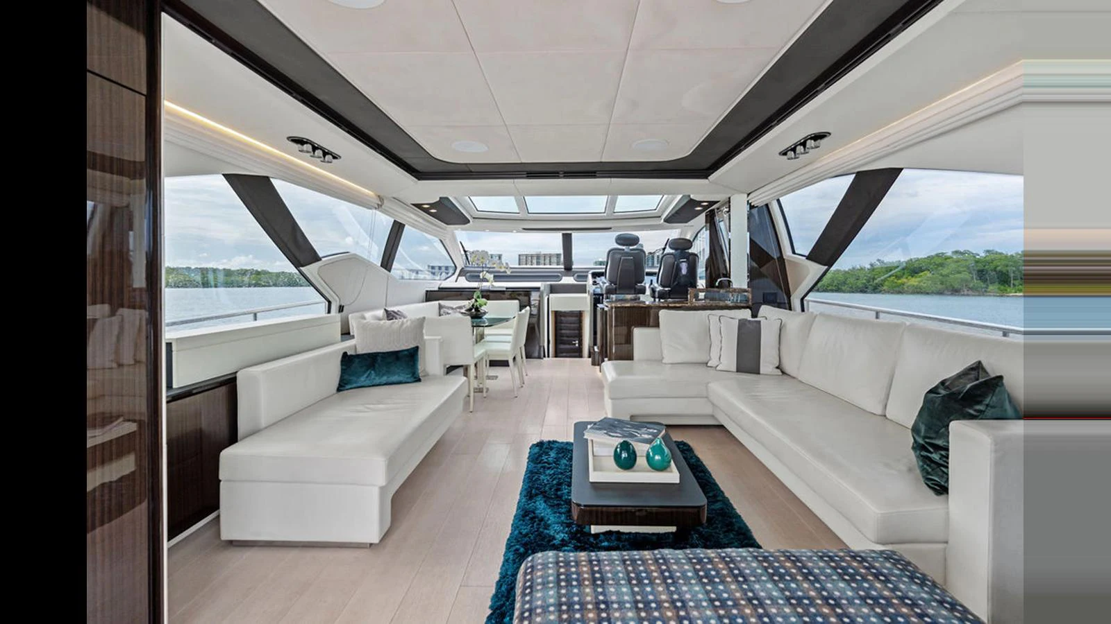 The salon features luxurious seating and modern decor with expansive windows offering stunning views. aboard VILLAGGIO Yacht for Sale