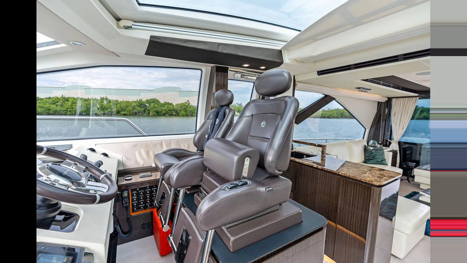 The helm station features luxurious seating and advanced navigation equipment with panoramic views. aboard VILLAGGIO Yacht for Sale