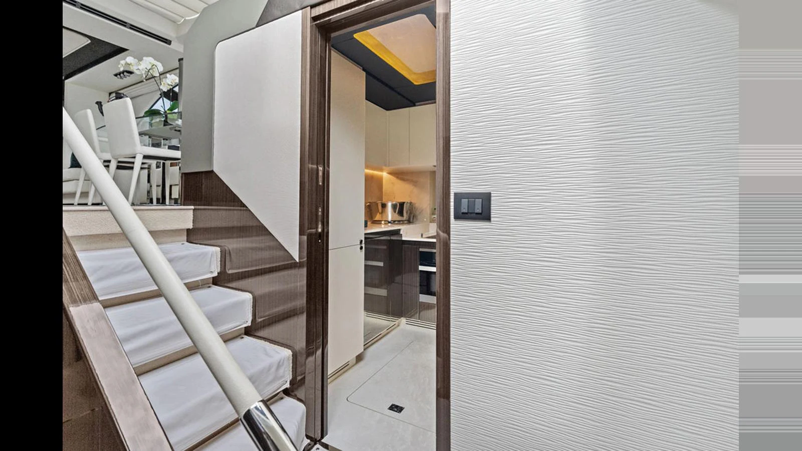 A modern stairway leads to a sleek kitchen area on this yacht. aboard VILLAGGIO Yacht for Sale