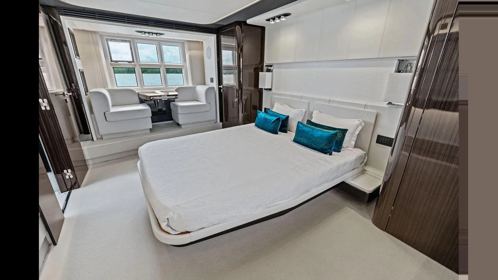 The master stateroom features a luxurious bed with elegant decor and a seating area by the windows. aboard VILLAGGIO Yacht for Sale