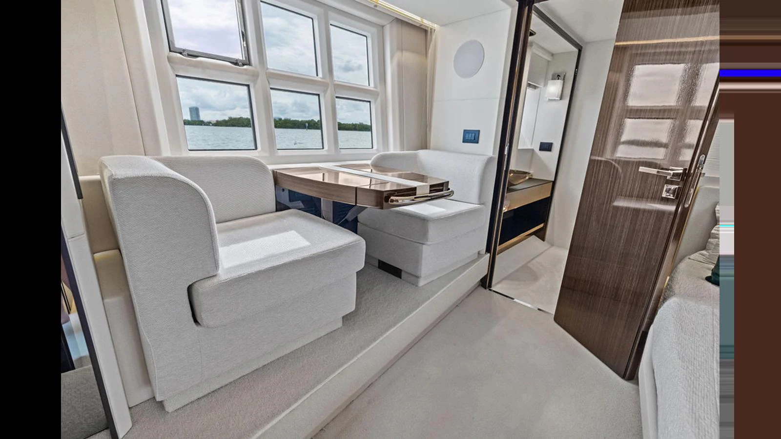 The yacht's interior features a cozy seating area with large windows providing ample natural light. aboard VILLAGGIO Yacht for Sale