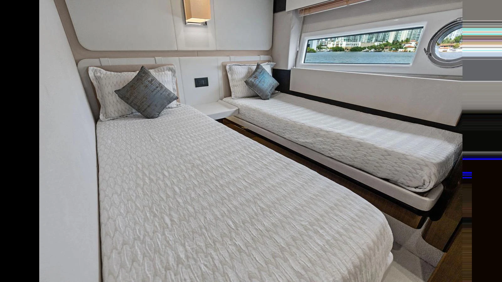The guest stateroom features two comfortable single beds with elegant bedding and a scenic window view. aboard VILLAGGIO Yacht for Sale