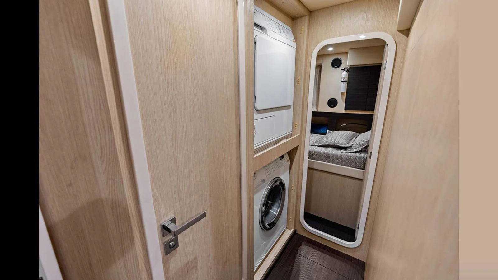 The yacht's interior features a compact laundry area with a washing machine and dryer, adjacent to a cozy sleeping quarters. aboard VILLAGGIO Yacht for Sale