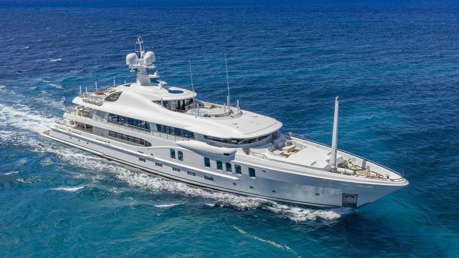 A luxurious yacht cruises through the vibrant blue waters, showcasing its elegant design and spacious decks. aboard NENINKA Yacht for Sale