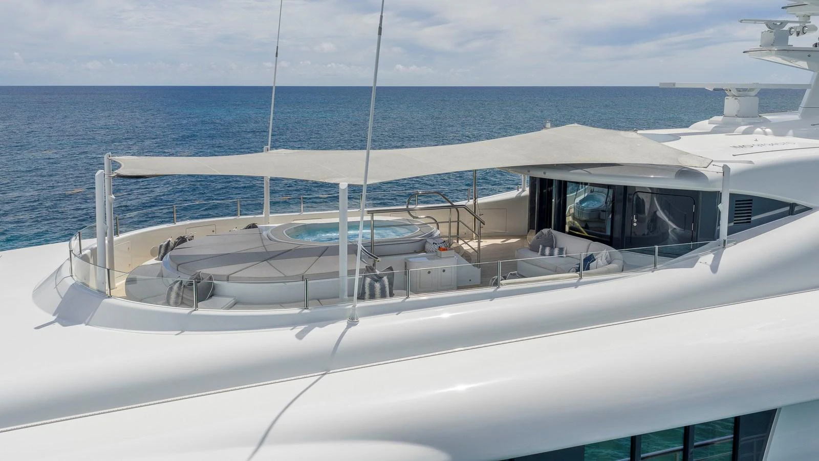 The sundeck features a luxurious jacuzzi and ample seating under a shade canopy. aboard NENINKA Yacht for Sale