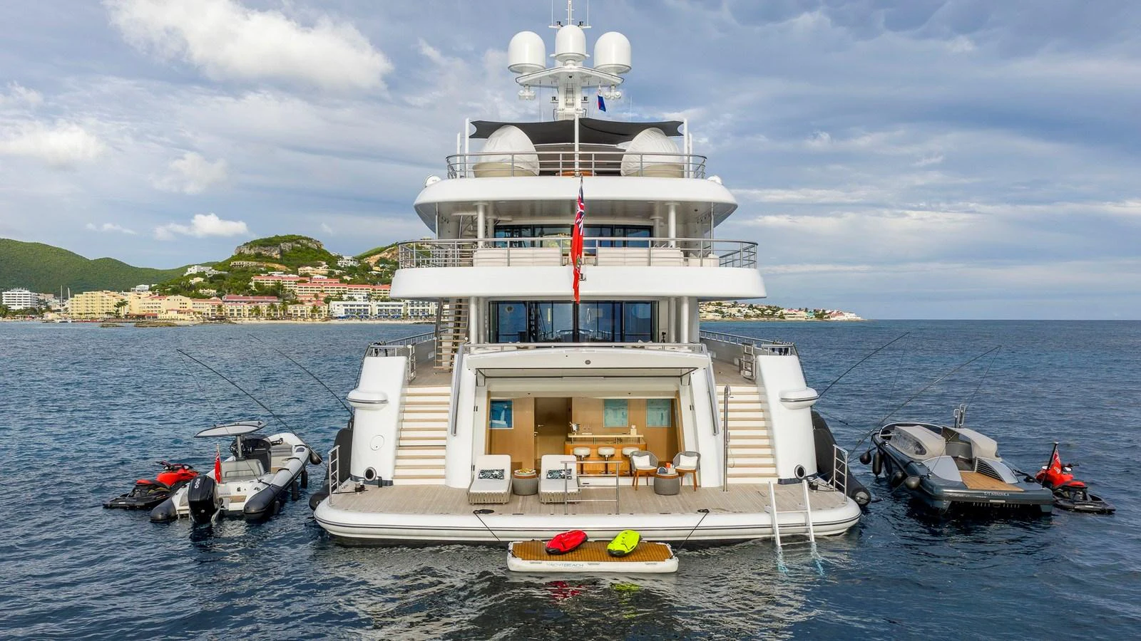 The yacht is anchored with various tenders and toys surrounding its aft deck. aboard NENINKA Yacht for Sale